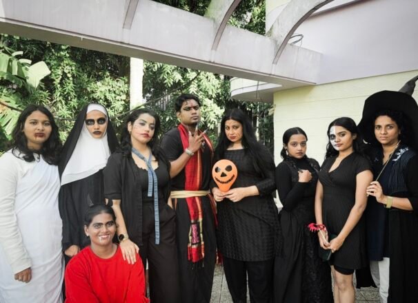 Students and faculty posing together in Halloween costumes at Halloween Fest INSD Trivandrum